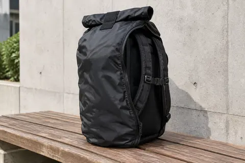 Housse noire Journext sur un sac à dos, avec le haut réglable et l’accès zippé aux bretelles visibles